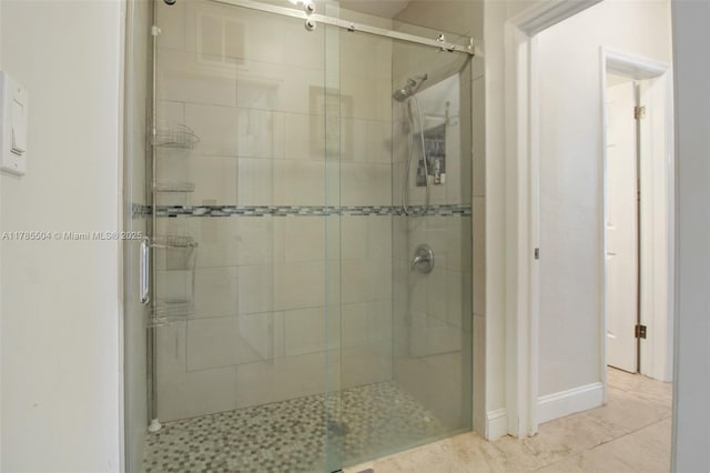 bathroom featuring baseboards and a stall shower