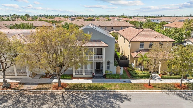11640 SW 243rd St, Homestead, FL 33032 - view of front facade featuring stucco siding, a tiled roof, a residential view, and a balcony