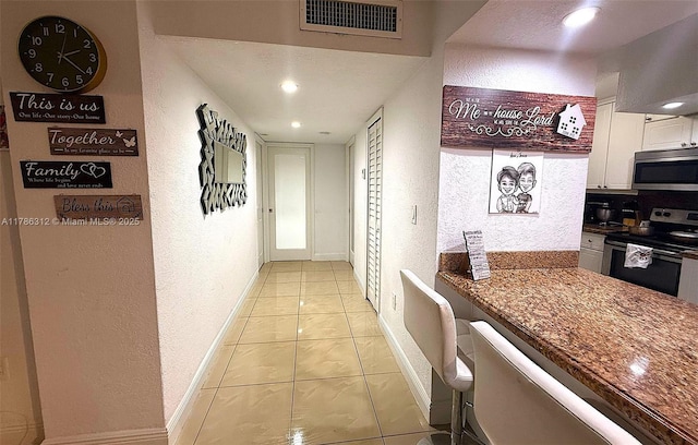 8820 Fontainebleau Blvd Unit 104, Miami, FL 33172 - hallway with baseboards, visible vents, recessed lighting, a textured wall, and light tile patterned floors