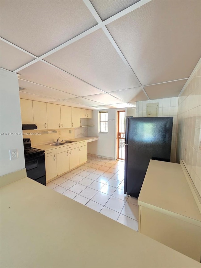 1900 W 54th St Unit 120, Hialeah, FL 33012 - kitchen with light tile patterned floors, light countertops, black appliances, a sink, and a paneled ceiling
