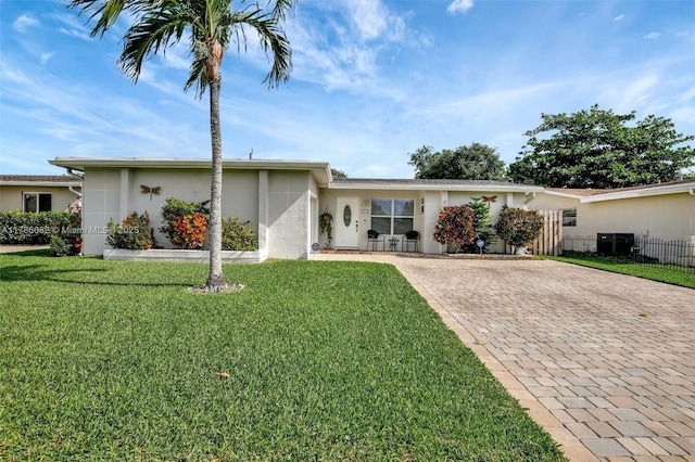 single story home with stucco siding, driveway, and a front lawn