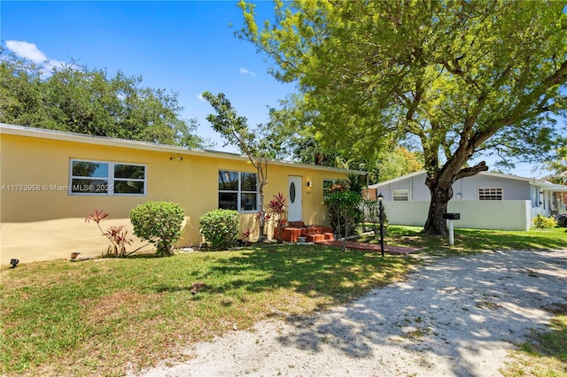 ranch-style house with a front yard and stucco siding