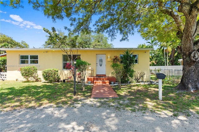 view of front of property featuring stucco siding and fence