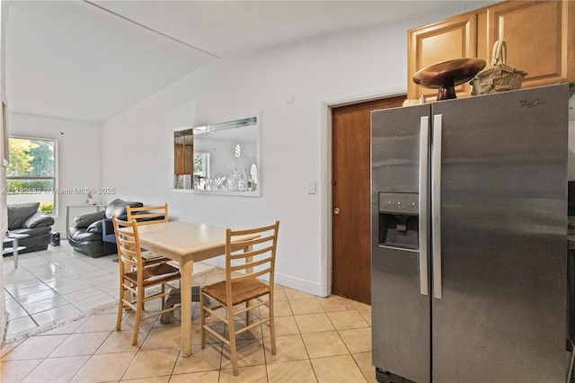 dining area with lofted ceiling and light tile patterned floors