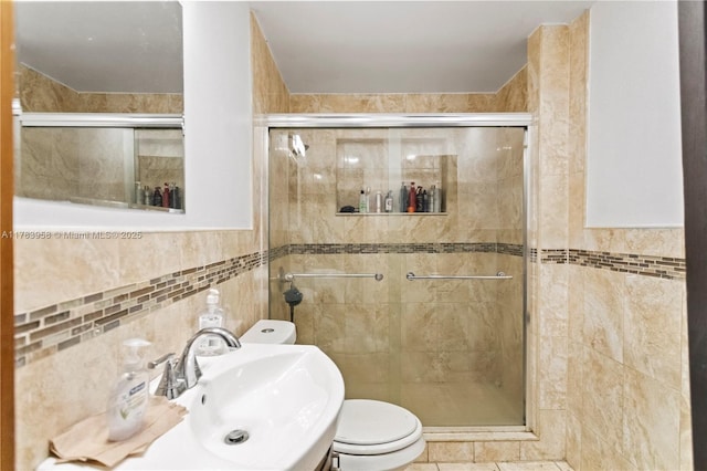 full bath featuring a stall shower, a sink, and tile walls