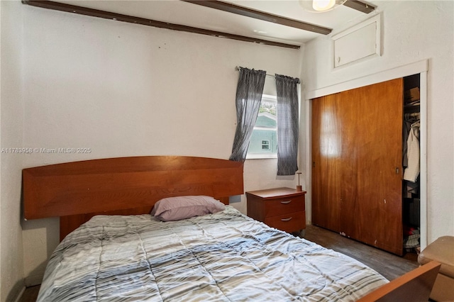 bedroom with vaulted ceiling, wood finished floors, and a closet