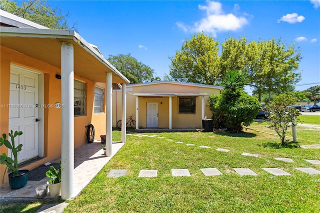 back of property featuring a yard and stucco siding