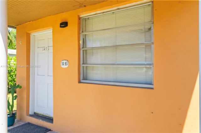 doorway to property featuring stucco siding