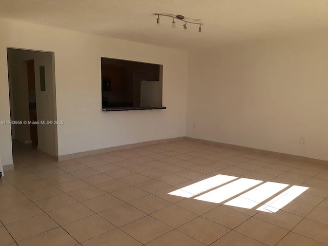 spare room with light tile patterned flooring and track lighting