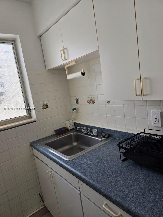 200 76th St Unit 57, Miami Beach, FL 33141 - kitchen with a sink, plenty of natural light, decorative backsplash, white cabinets, and tile walls