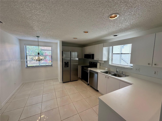6081 SE Landing Way Unit 8, Stuart, FL 34997 - kitchen with appliances with stainless steel finishes, a sink, light countertops, a textured ceiling, and white cabinetry