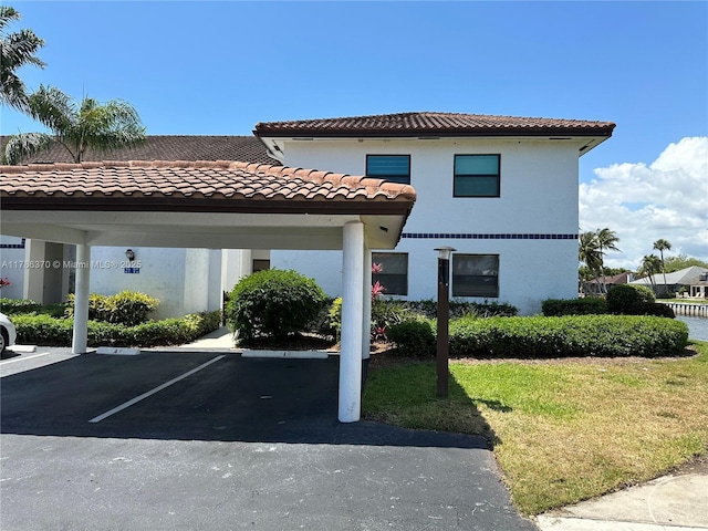 6081 SE Landing Way Unit 8, Stuart, FL 34997 - view of front of home with covered parking, a tile roof, and stucco siding