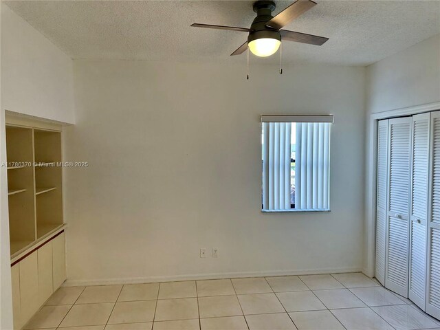 6081 SE Landing Way Unit 8, Stuart, FL 34997 - unfurnished bedroom featuring a textured ceiling, light tile patterned flooring, a closet, and baseboards
