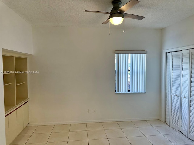 6081 SE Landing Way Unit 8, Stuart, FL 34997 - unfurnished bedroom featuring a textured ceiling, light tile patterned floors, a closet, and a ceiling fan