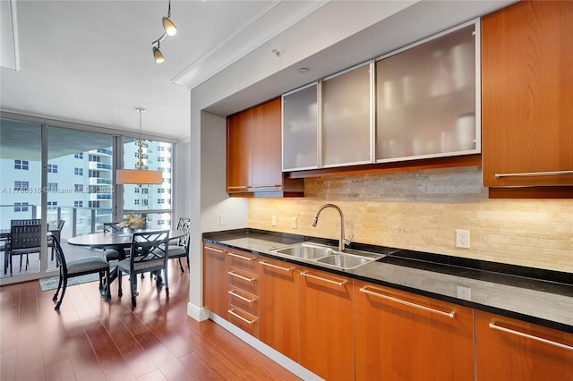 3101 S Ocean Dr Unit 701, Hollywood, FL 33019 - kitchen featuring a sink, dark wood-style flooring, expansive windows, backsplash, and brown cabinetry