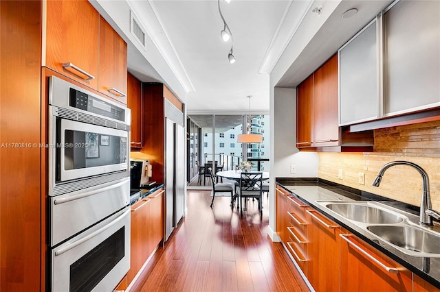3101 S Ocean Dr Unit 701, Hollywood, FL 33019 - kitchen featuring a sink, brown cabinets, dark wood-type flooring, decorative backsplash, and a wall of windows