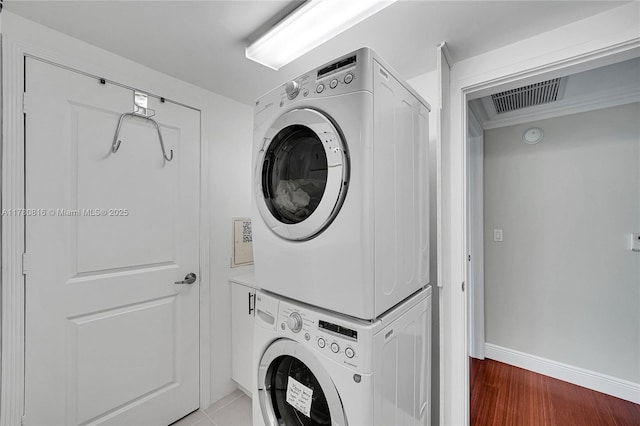 3101 S Ocean Dr Unit 701, Hollywood, FL 33019 - laundry room with stacked washer and clothes dryer, baseboards, and wood finished floors