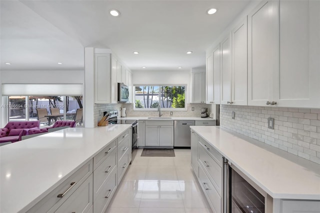 2506 NE 30th St, Fort Lauderdale, FL 33306 - kitchen with appliances with stainless steel finishes, beverage cooler, decorative backsplash, a sink, and light countertops