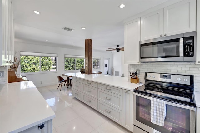 2506 NE 30th St, Fort Lauderdale, FL 33306 - kitchen featuring appliances with stainless steel finishes, light tile patterned flooring, light countertops, backsplash, and recessed lighting