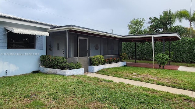 521 N 70th Way, Hollywood, FL 33024 - view of side of home featuring a sunroom and a lawn