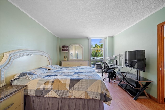 bedroom featuring crown molding, wood finished floors, and a textured ceiling