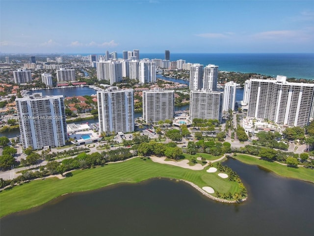 drone / aerial view featuring a water view, golf course view, and a view of city
