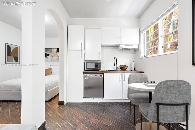 359 Meridian Ave Unit A105, Miami Beach, FL 33139 - kitchen with dishwasher, black microwave, extractor fan, white cabinets, and arched walkways