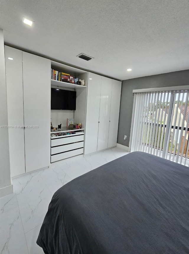 bedroom with visible vents, baseboards, marble finish floor, and a textured ceiling