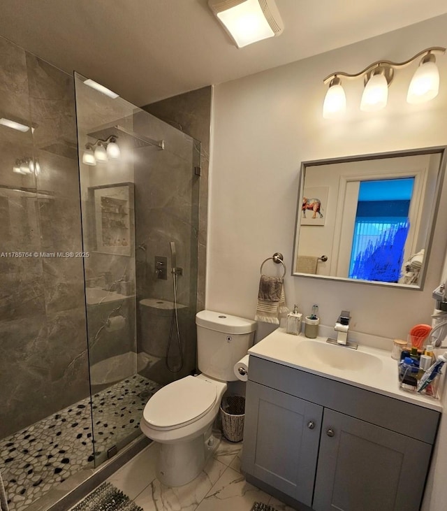 bathroom with marble finish floor, toilet, walk in shower, and vanity