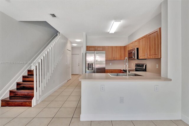 7848 Catalina Cir Unit 7848, Tamarac, FL 33321 - kitchen featuring stainless steel appliances, light countertops, a peninsula, a sink, and light tile patterned flooring