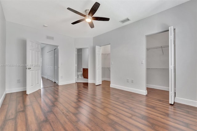 7848 Catalina Cir Unit 7848, Tamarac, FL 33321 - unfurnished bedroom with a walk in closet, wood finished floors, baseboards, and connected bathroom