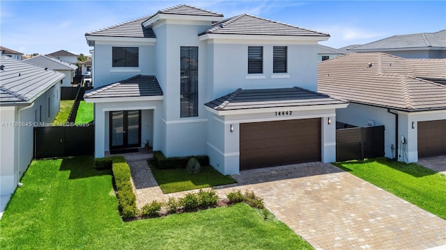 view of front of house featuring french doors, a tile roof, stucco siding, and decorative driveway