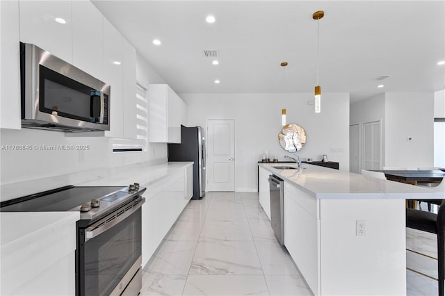kitchen featuring modern cabinets, marble finish floor, appliances with stainless steel finishes, and a sink