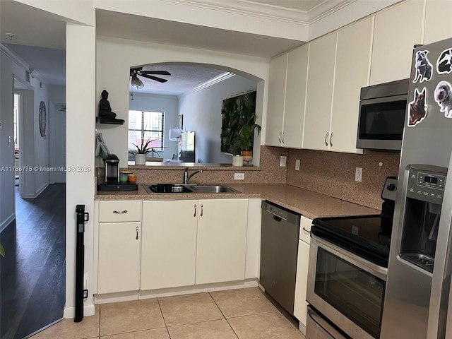 22701 SW 88th Pl Unit 203-9, Cutler Bay, FL 33190 - kitchen featuring appliances with stainless steel finishes, ornamental molding, ceiling fan, arched walkways, and backsplash