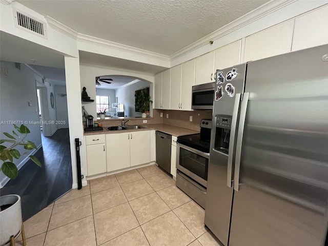 22701 SW 88th Pl Unit 203-9, Cutler Bay, FL 33190 - kitchen featuring appliances with stainless steel finishes, ornamental molding, a textured ceiling, light tile patterned flooring, and ceiling fan