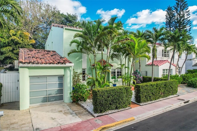 837 Espanola Way, Miami Beach, FL 33139 - view of front of property featuring a tile roof, concrete driveway, stucco siding, and fence