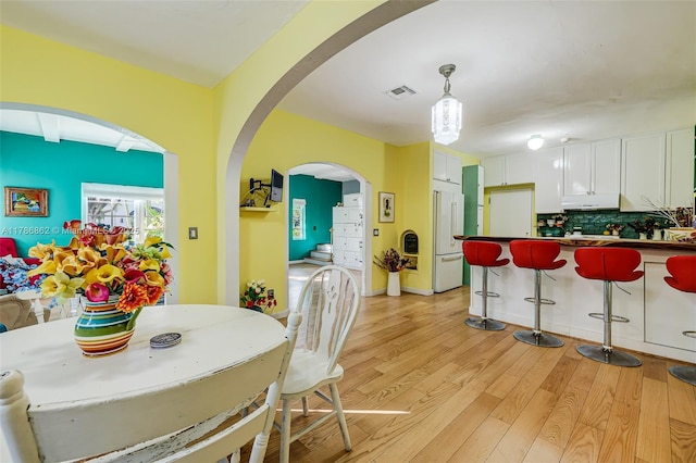 837 Espanola Way, Miami Beach, FL 33139 - dining room featuring light wood finished floors, visible vents, and arched walkways