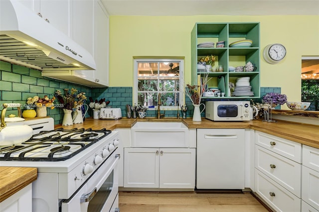 837 Espanola Way, Miami Beach, FL 33139 - kitchen with tasteful backsplash, wooden counters, under cabinet range hood, white appliances, and white cabinetry