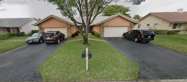 single story home with a tiled roof, a front lawn, driveway, an attached garage, and stucco siding