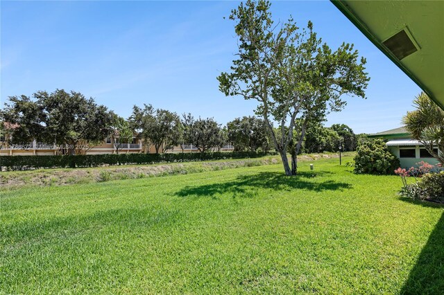 632 Hummingbird Ln, Delray Beach, FL 33445 - rear view of property with a lawn and a sunroom