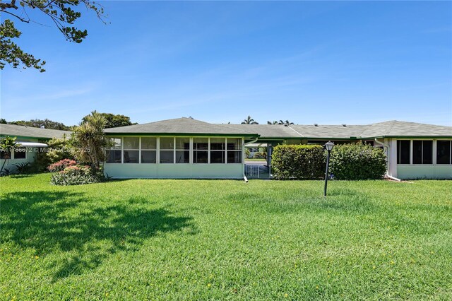 632 Hummingbird Ln, Delray Beach, FL 33445 - back of house featuring a sunroom and a yard