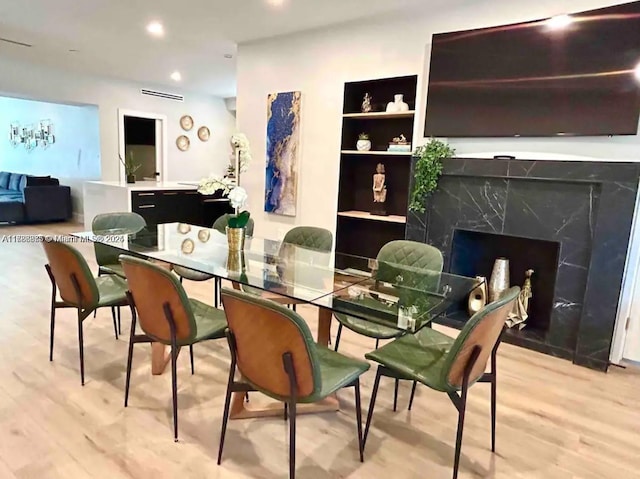 2360 SW 12th St, Miami, FL 33135 - dining room featuring light wood-style flooring, visible vents, recessed lighting, a fireplace, and built in shelves