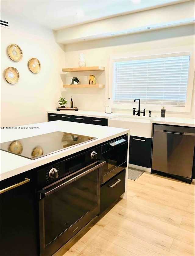 2360 SW 12th St, Miami, FL 33135 - bar with light wood finished floors, a sink, black electric cooktop, oven, and dishwasher