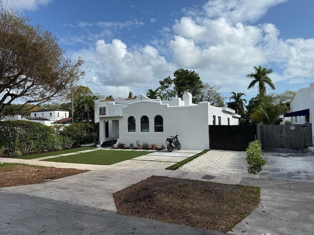 2360 SW 12th St, Miami, FL 33135 - mediterranean / spanish-style home with stucco siding, a gate, fence, a front yard, and concrete driveway
