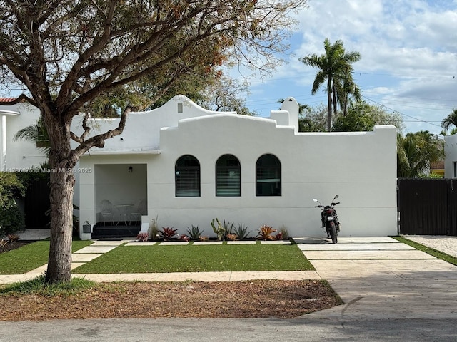 2360 SW 12th St, Miami, FL 33135 - mediterranean / spanish home featuring a front lawn, driveway, stucco siding, and fence