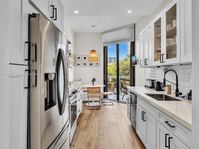 20191 E Country Club Dr Unit 311, Aventura, FL 33180 - kitchen featuring a sink, light countertops, glass insert cabinets, stainless steel appliances, and light wood-style flooring