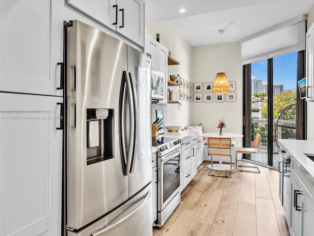 20191 E Country Club Dr Unit 311, Aventura, FL 33180 - kitchen with open shelves, stainless steel appliances, light countertops, decorative light fixtures, and white cabinetry