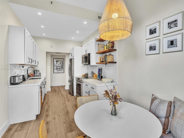 20191 E Country Club Dr Unit 311, Aventura, FL 33180 - kitchen featuring open shelves, a sink, light wood-type flooring, stainless steel appliances, and backsplash
