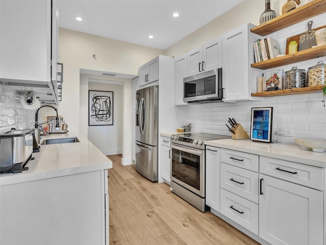 20191 E Country Club Dr Unit 311, Aventura, FL 33180 - kitchen with backsplash, light wood-type flooring, stainless steel appliances, and a sink