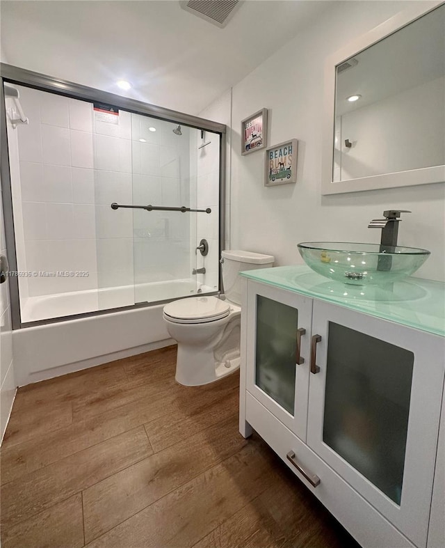 575 Crandon Blvd Unit 707, Key Biscayne, FL 33149 - full bath with enclosed tub / shower combo, wood finished floors, visible vents, toilet, and vanity